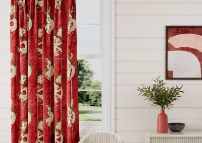 red and patterned curtain in front of a closed window with white walls